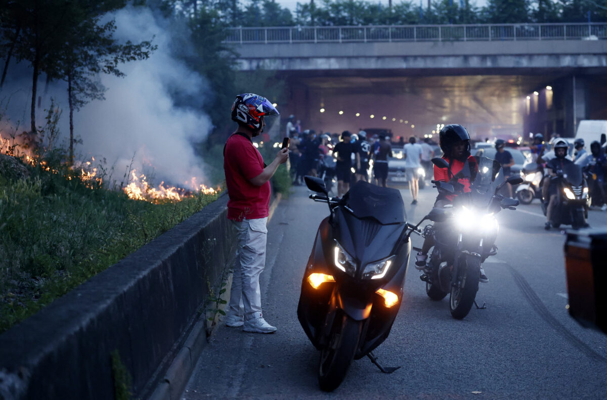 Soccer Football - UEFA Champions League - Paris St Germain fans in Paris watch the Final - Parc des Princes, Paris, France - May 30, 2026 Fires burn on the grass verge beside the road as Paris St Germain fans celebrate after winning the Champions League REUTERS