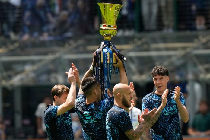 Inter Milan's Lautaro Martinez holds the trophy of the Italy's cup prior to the start of a Serie A soccer match between Inter Milan and Hellas Verona, in Milan, Italy, Sunday, May 17, 2026. (AP Photo